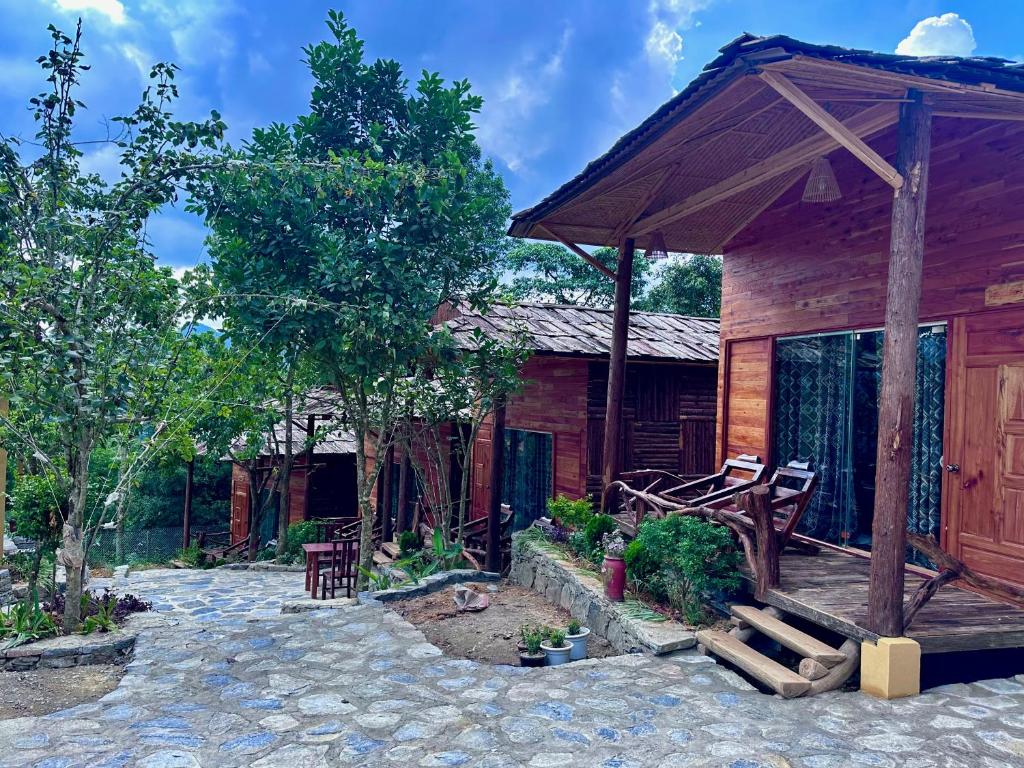 una baita di tronchi con veranda e patio. di Bac Ha Charm Stay a Bắc Hà