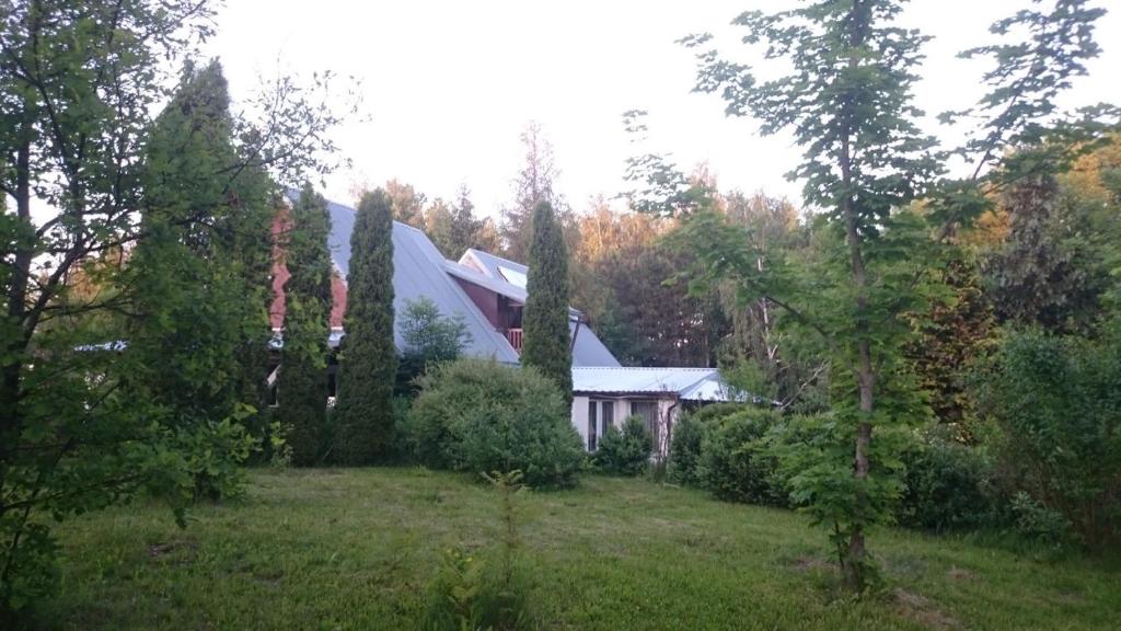 una casa en medio de un patio con árboles en Wynajem pokoi-Burniszki, en Burniszki