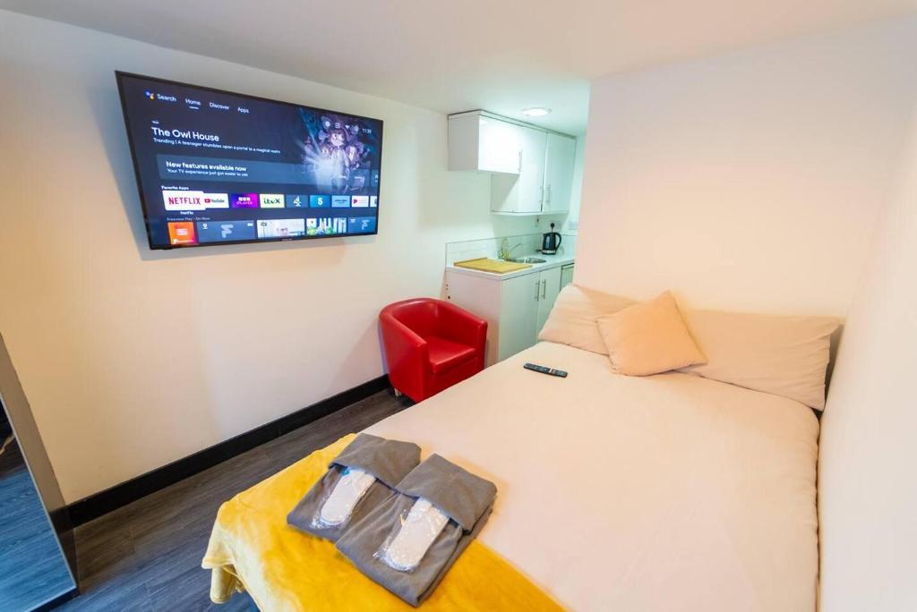 a bedroom with a bed with a tv on the wall at Stunning 1-Bed Studio in Birmingham available in Birmingham