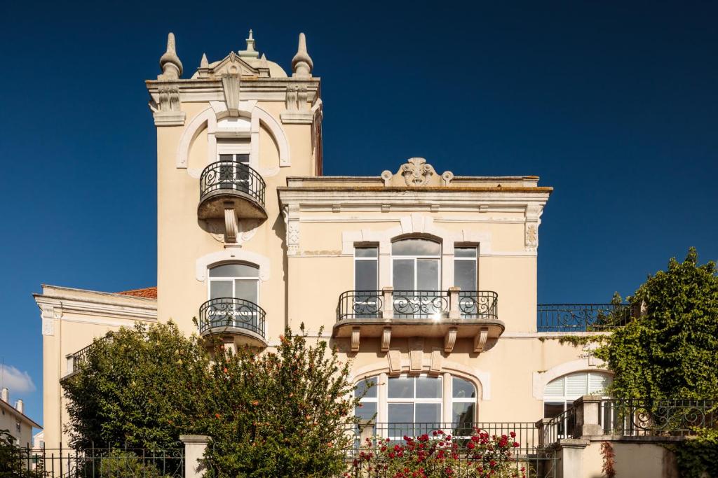 a tall building with two balconies and a tower at Cheese & Wine Lapa in Lisbon