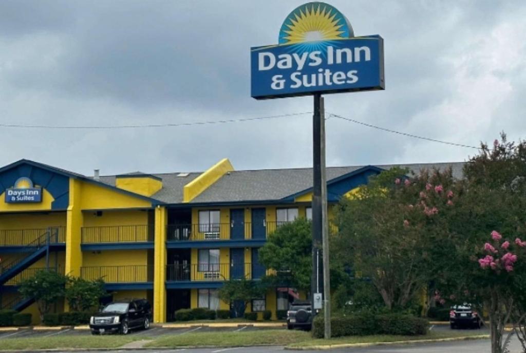 a sign in front of a days inn and suites at Days Inn & Suites Mobile in Tillmans Corner