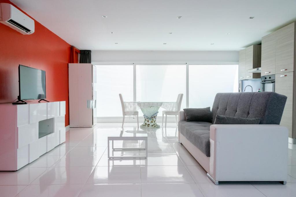 un soggiorno con divano e tavolo di Playa 4 a solo 3 min - Apartamento en Castelldefels a Castelldefels