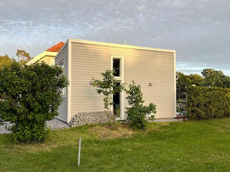 uma pequena casa branca num campo com um quintal em Nybyggt gästhus nära havet och Göteborg em Kullavik