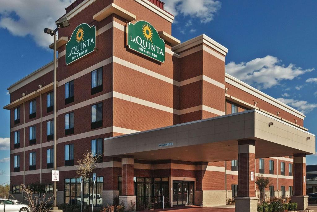 a large brick building with two signs on it at La Quinta by Wyndham Edmond in Edmond