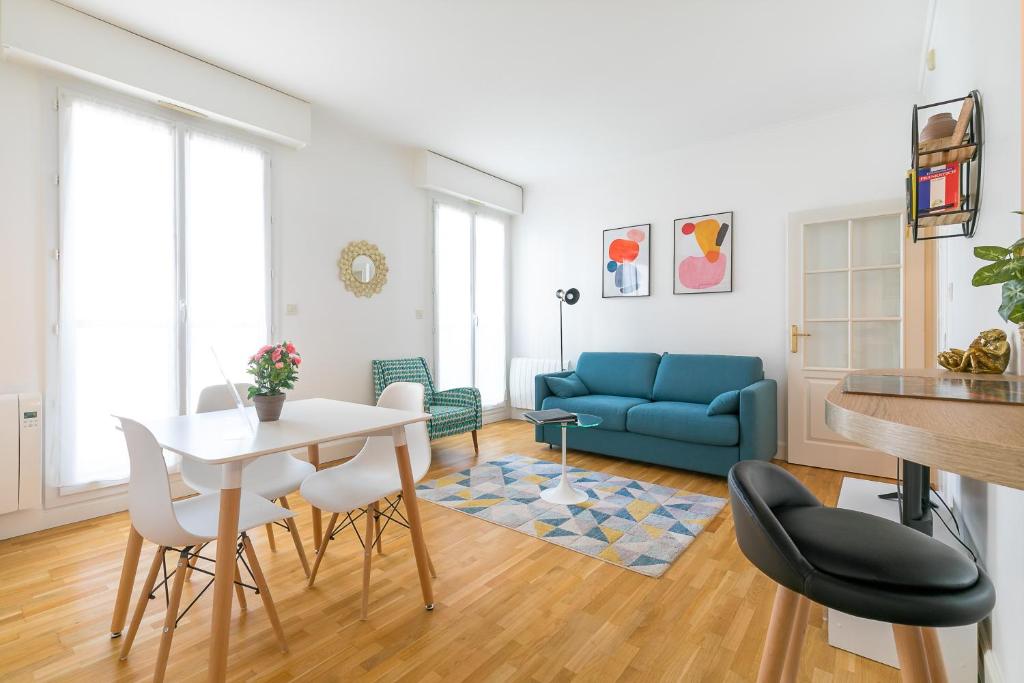 un salon avec une table et un canapé bleu dans l'établissement 56-chabot-charny, à Dijon