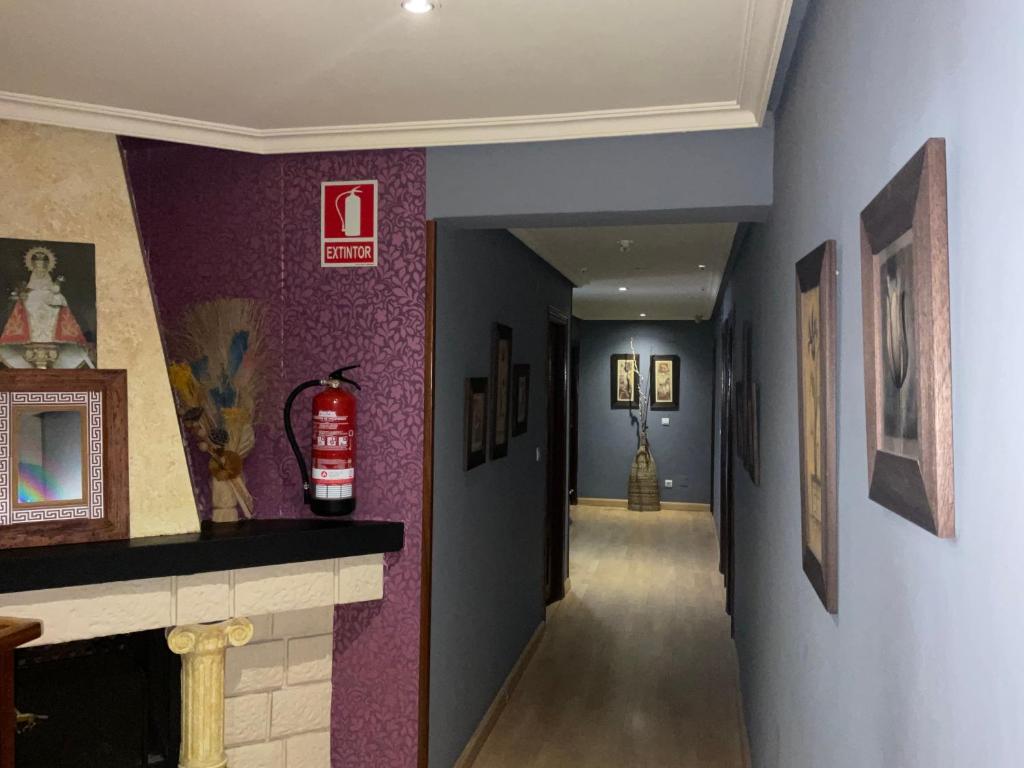 a hallway with purple walls and a fire extinguisher on the wall at La Chalana in Pola de Laviana