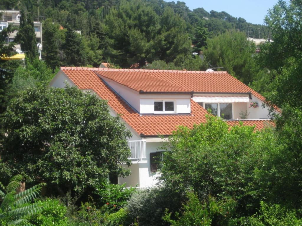 een wit huis met een oranje dak bij Apartment Green Oasis in Split