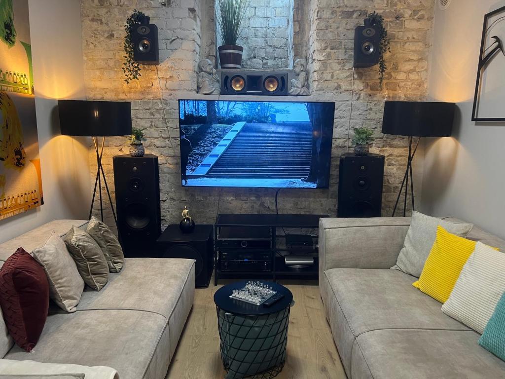 - un salon avec deux canapés et une télévision à écran plat dans l'établissement Ofek's place - Midtown TLV, à Tel Aviv