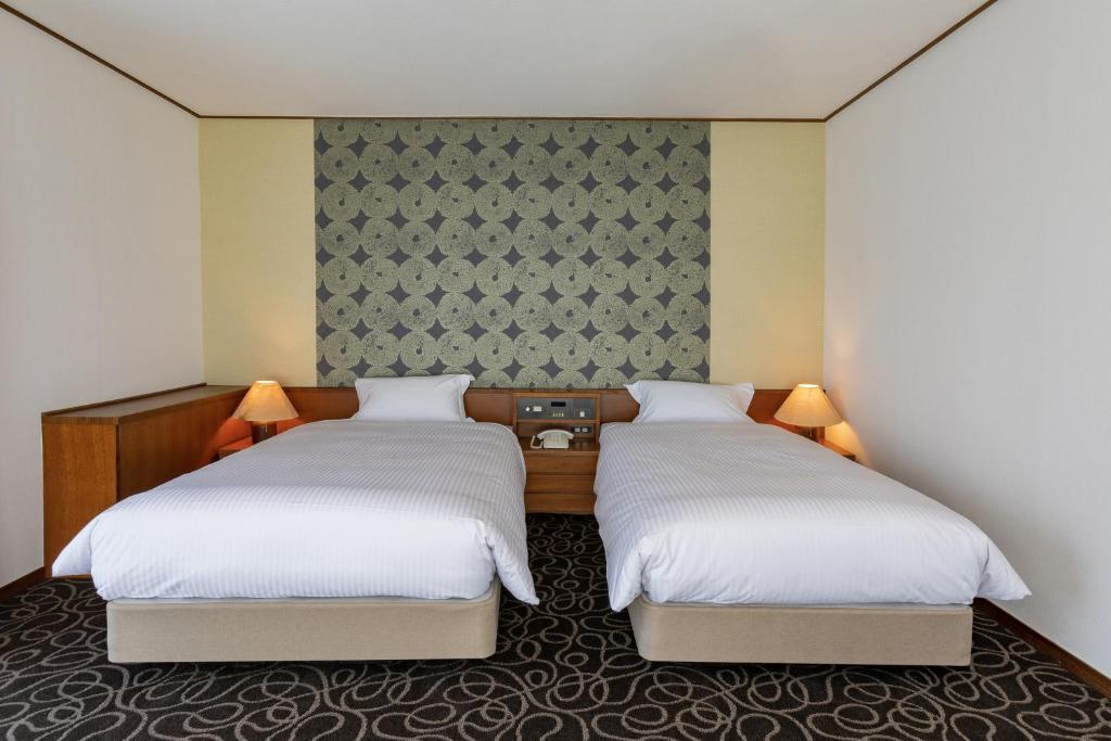Postel nebo postele na pokoji v ubytování Suikouen Hotel