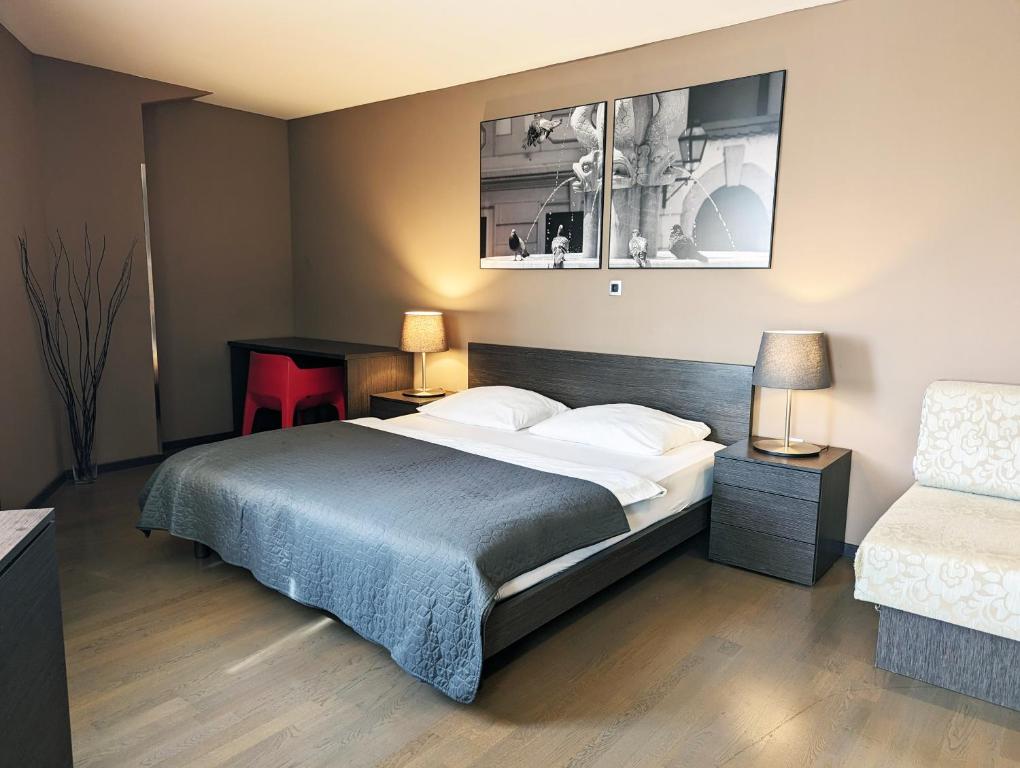 una camera con un letto e un tavolo e due lampade di Nitro Rooms a Lubiana