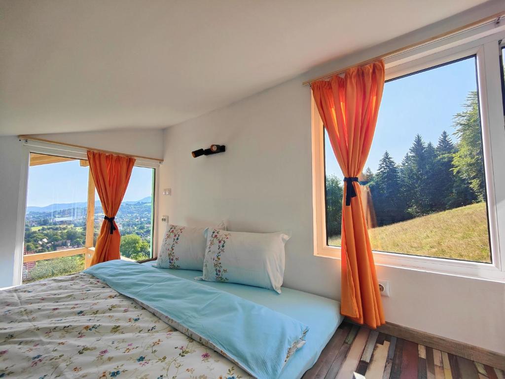 a bedroom with a bed and a large window at Rainbow Chalet in Bran