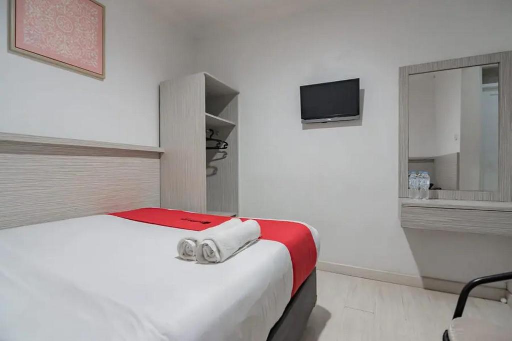 Postel nebo postele na pokoji v ubytování RedDoorz at Arwiga Hotel near RS Hasan Sadikin Bandung
