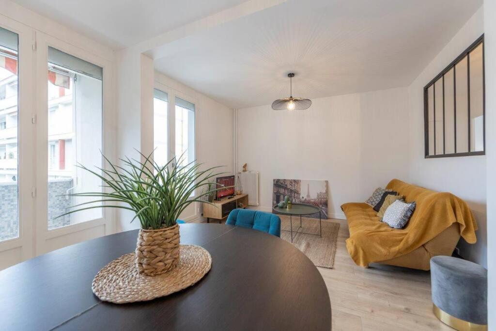 uma sala de estar com uma mesa com uma planta em Le Camille YourHostHelper em Rhut