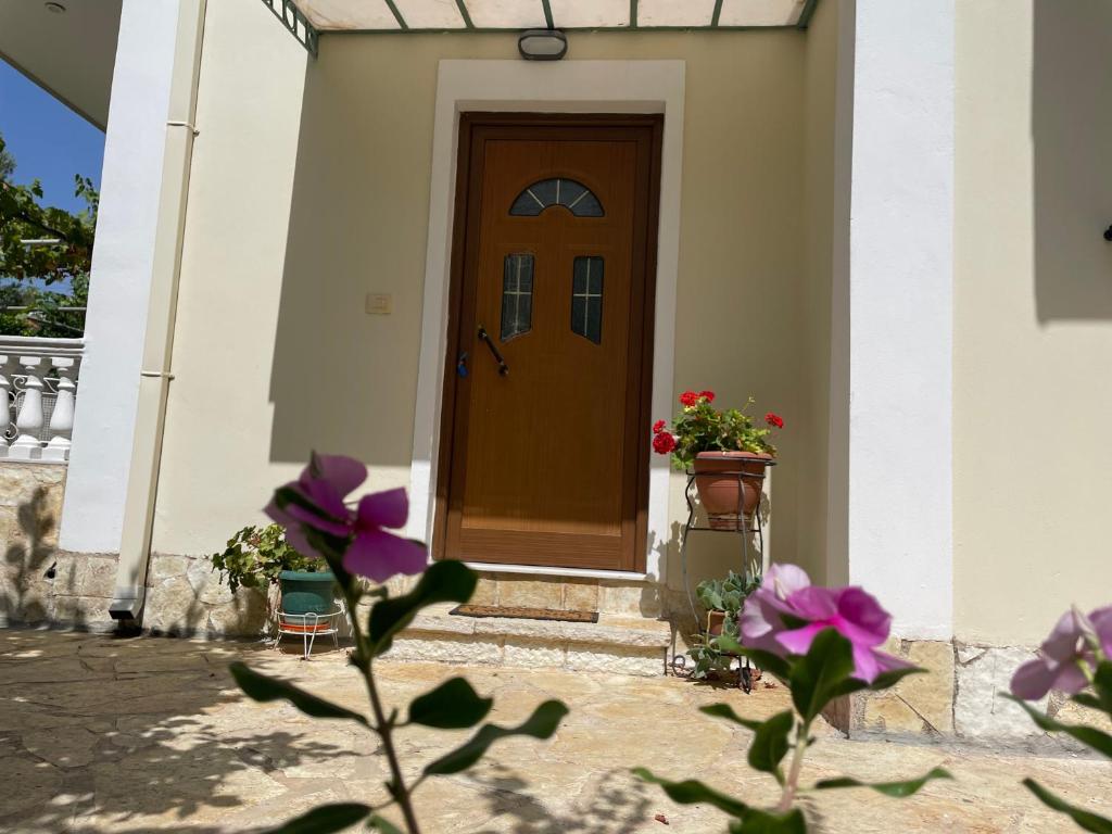 eine Tür eines Hauses mit Blumen davor in der Unterkunft Miranda's Apartments & Rooms in Sarandë