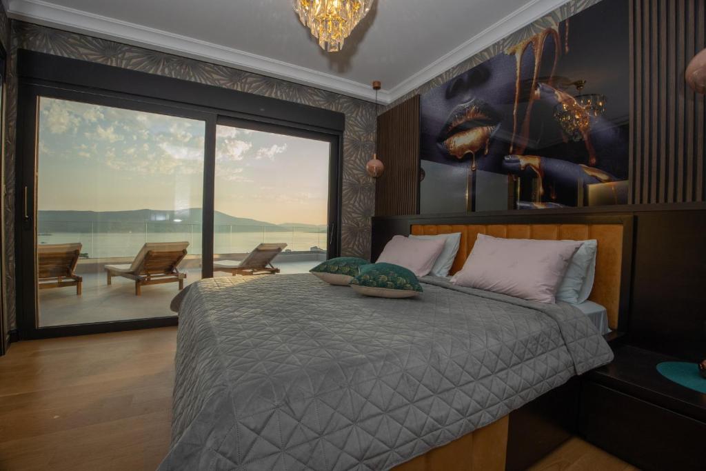 a bedroom with a large bed with a large window at Luxury Villa Joy with Pool in Tivat