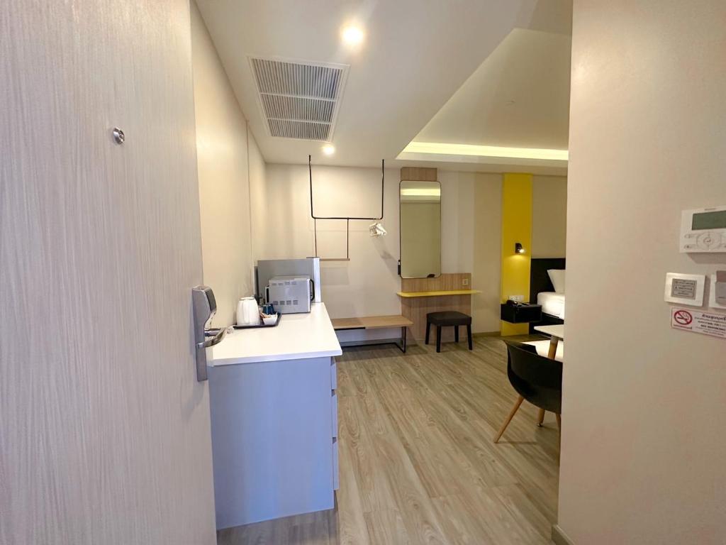 A compact studio interior showing the entry, kitchenette and dressing workspace together.