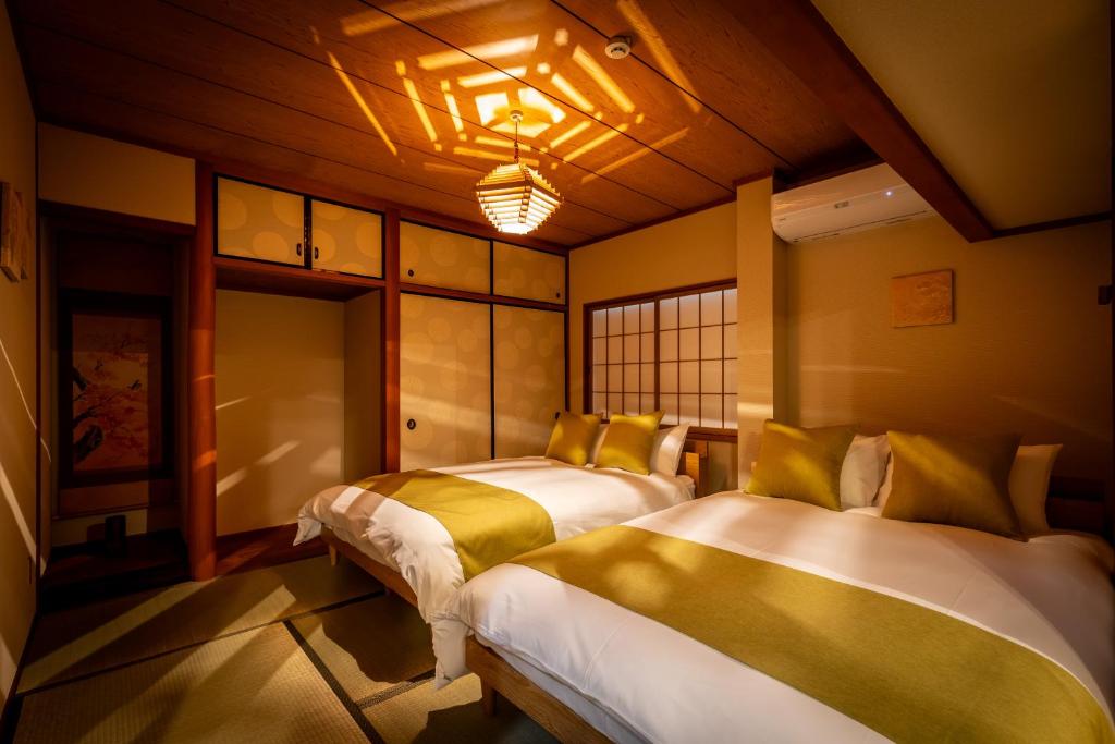 a bedroom with two beds in a room at Chikyuutabikazoku　Kintetsu-Nara Ekimae in Nara