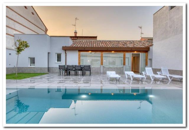 a swimming pool in front of a house at Casa Rural Duran in Mocejón