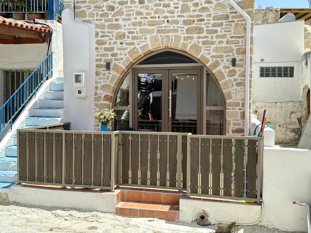 een poort voor een gebouw met een deur bij Camara House in Pitsidia