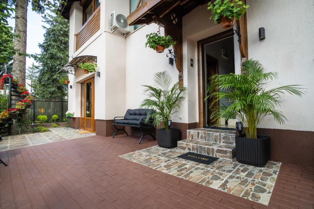 a patio with potted plants in front of a house at i3 Boutique Apart in Bacău