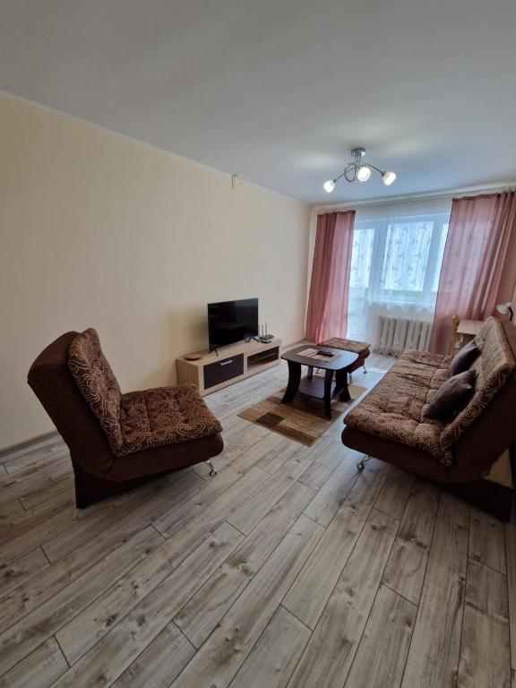 un salon avec deux chaises, un canapé et une télévision dans l'établissement Lima C, à Druskininkai