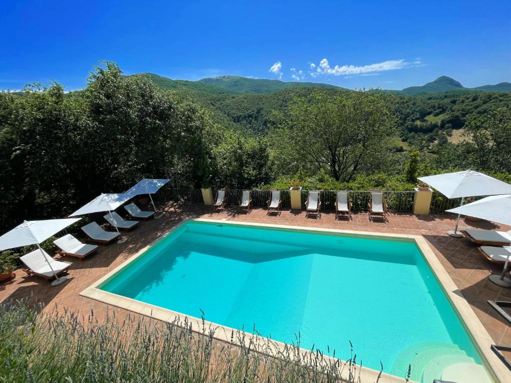 - une piscine avec des chaises longues et des parasols dans l'établissement Spoleto Splash Cisternasleeps 23wifiaircon - cute with beautiful garden, à Strettura