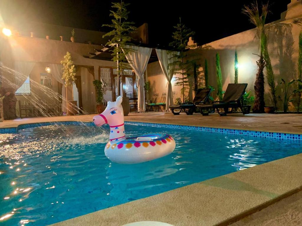 un cavallo gonfiabile in piscina di notte di Villa brek a Marrakech