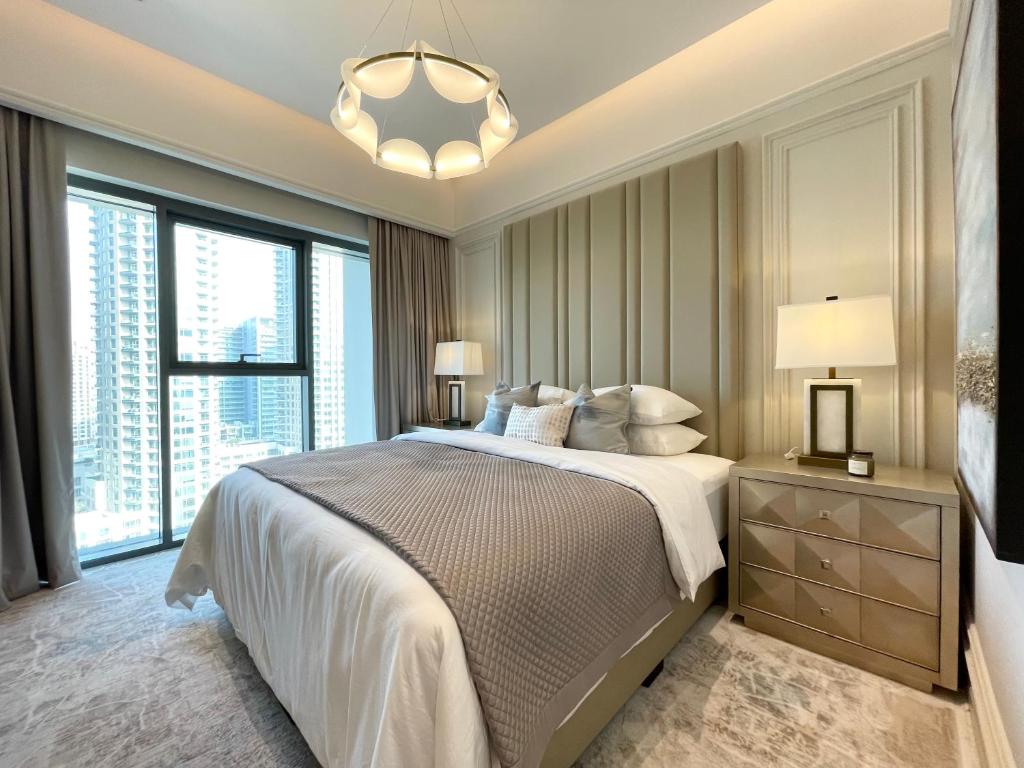 a bedroom with a large bed and a chandelier at Luxurious one-bedroom very close to Dubai Mall in Dubai