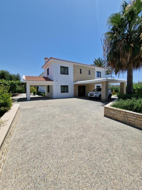 Paphos的住宿－Luxury 6 bedrooms villa in Cyprus，前面有车道的房子
