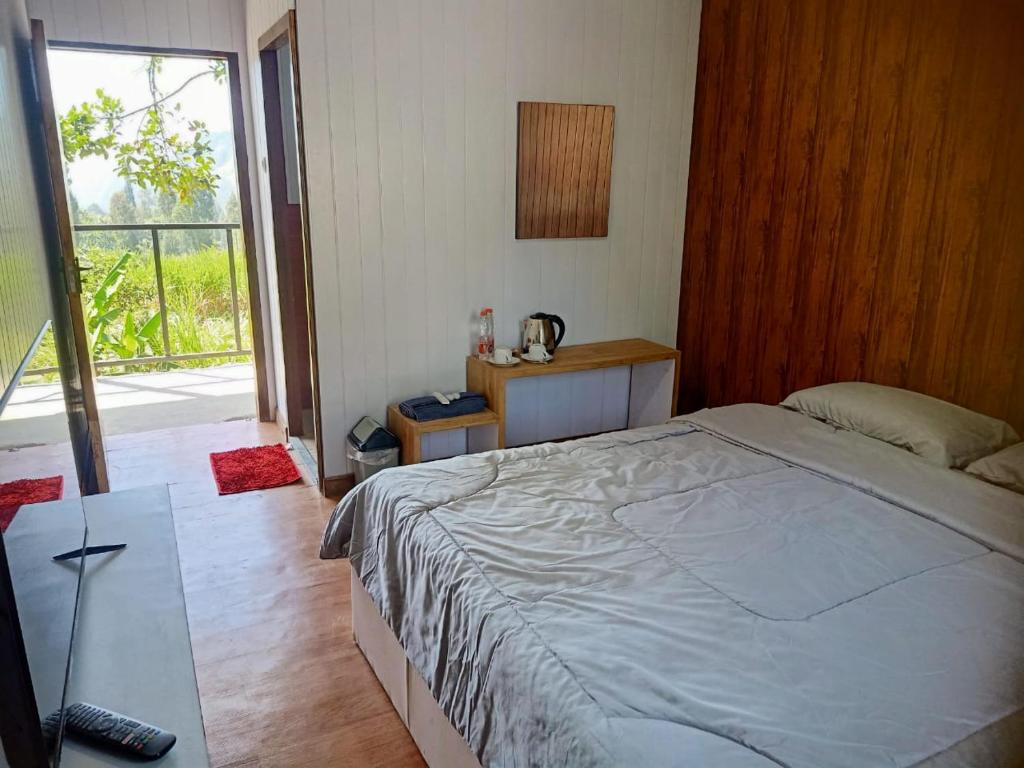 - une chambre avec un lit et une grande fenêtre dans l'établissement Istana Bromo Resort, à Bromo