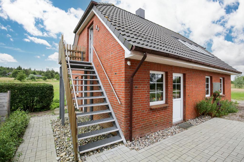 a small red brick house with a spiral staircase at Nordsee & Wald in Husum
