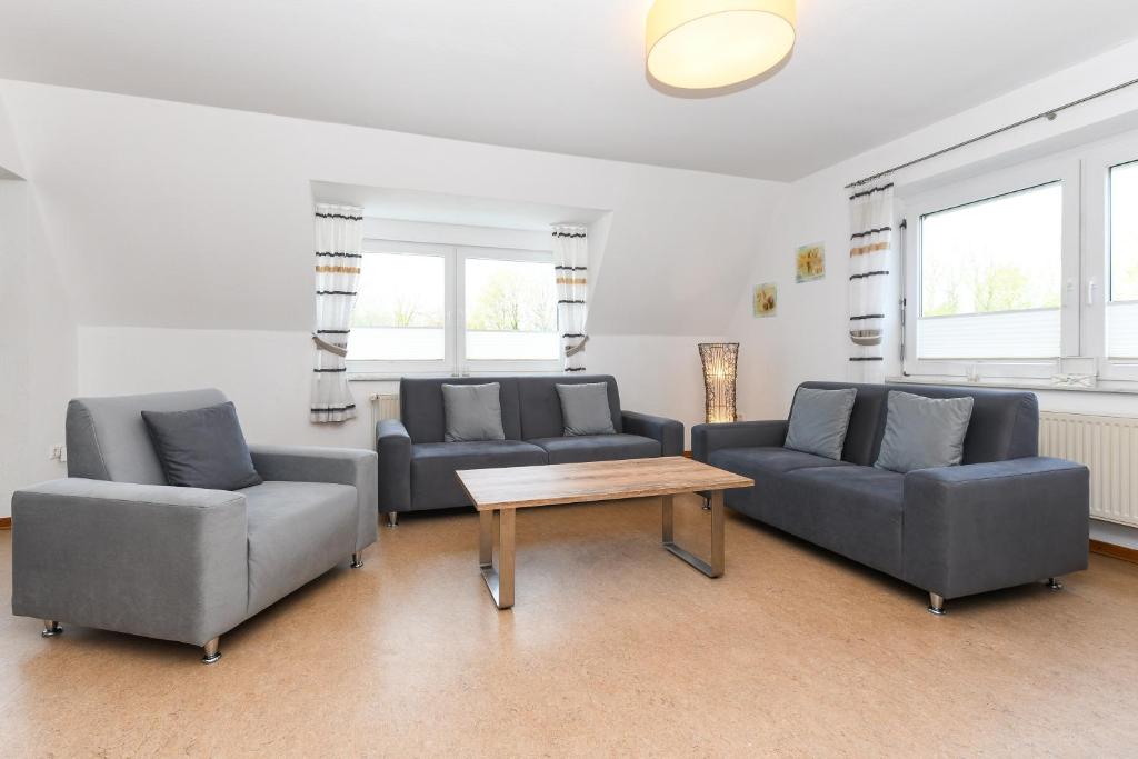 a living room with two couches and a coffee table at Ferienwohnung Inselblick in Bensersiel