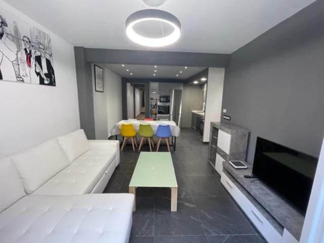 a living room with a white couch and a table at APARTAMENTO TROMPETA GaRaJe in Logroño