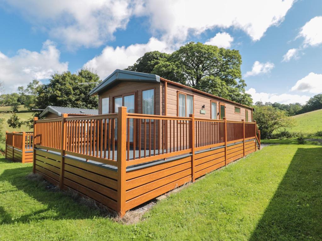 a modular home with a deck on the grass at Lodge 10 in Winscombe