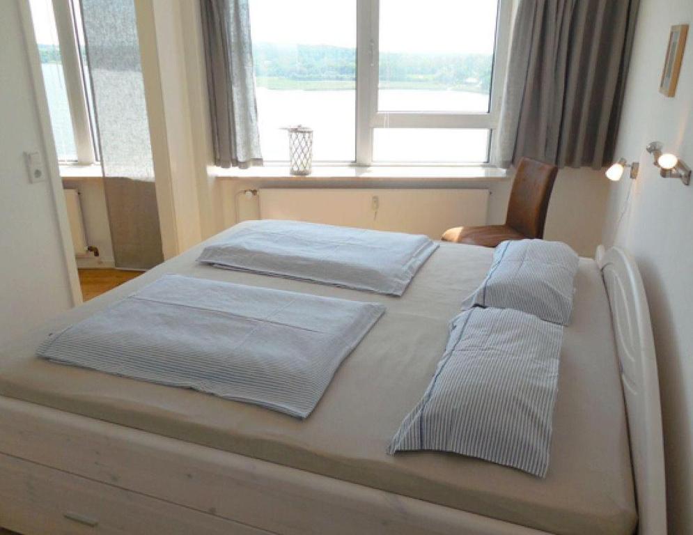a bedroom with a bed with two pillows and a window at Ferienwohnung-Seemoewe in Schleswig