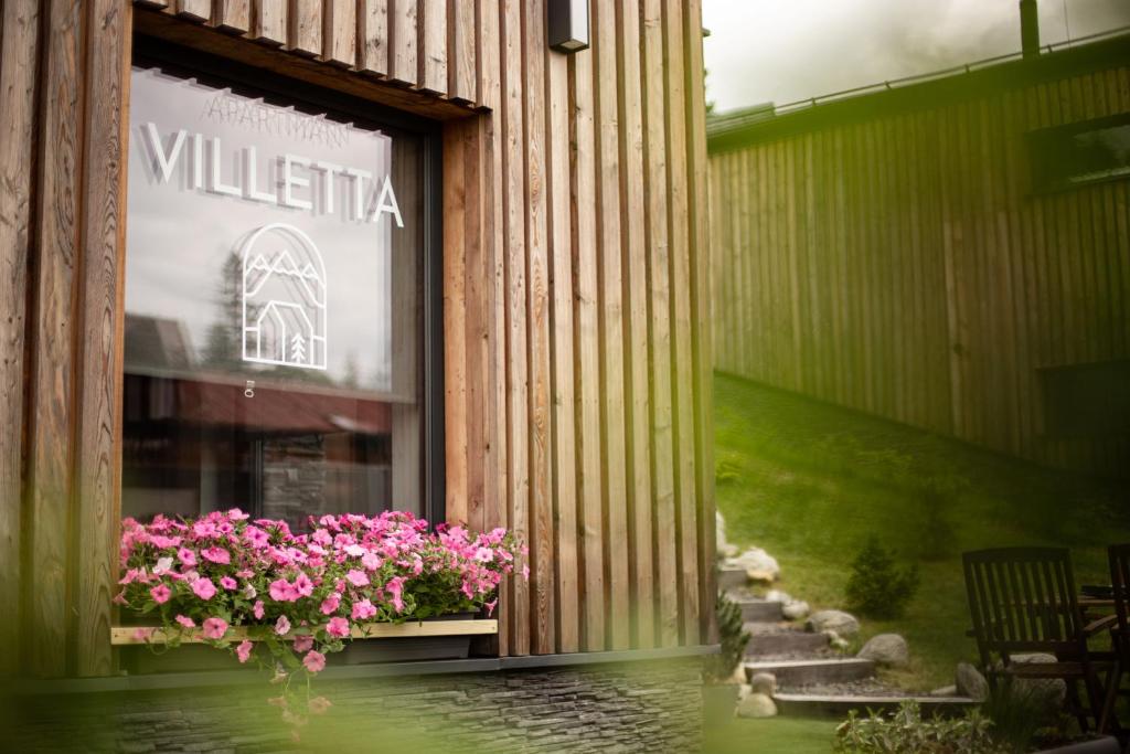 a store front with pink flowers in a window at VILLETTA Apartmán in Liptovský Mikuláš