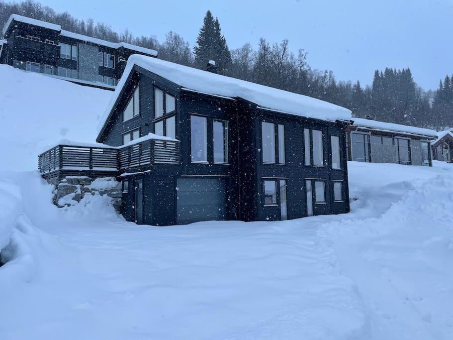 a house with snow on the roof in the snow at Hodlekvevegen 308 - Flott hytte midt i skisenteret in Sogndal