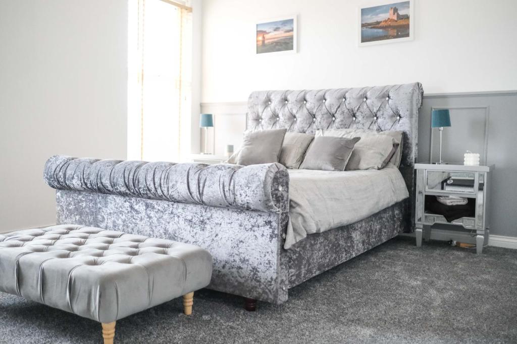 a bedroom with a large bed with a tufted headboard at Eia Street Apartments Belfast in Belfast