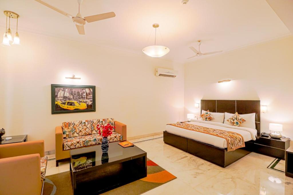 Habitación de hotel con cama y sofá en Ahuja Residency Cyber City I, en Gurgaon