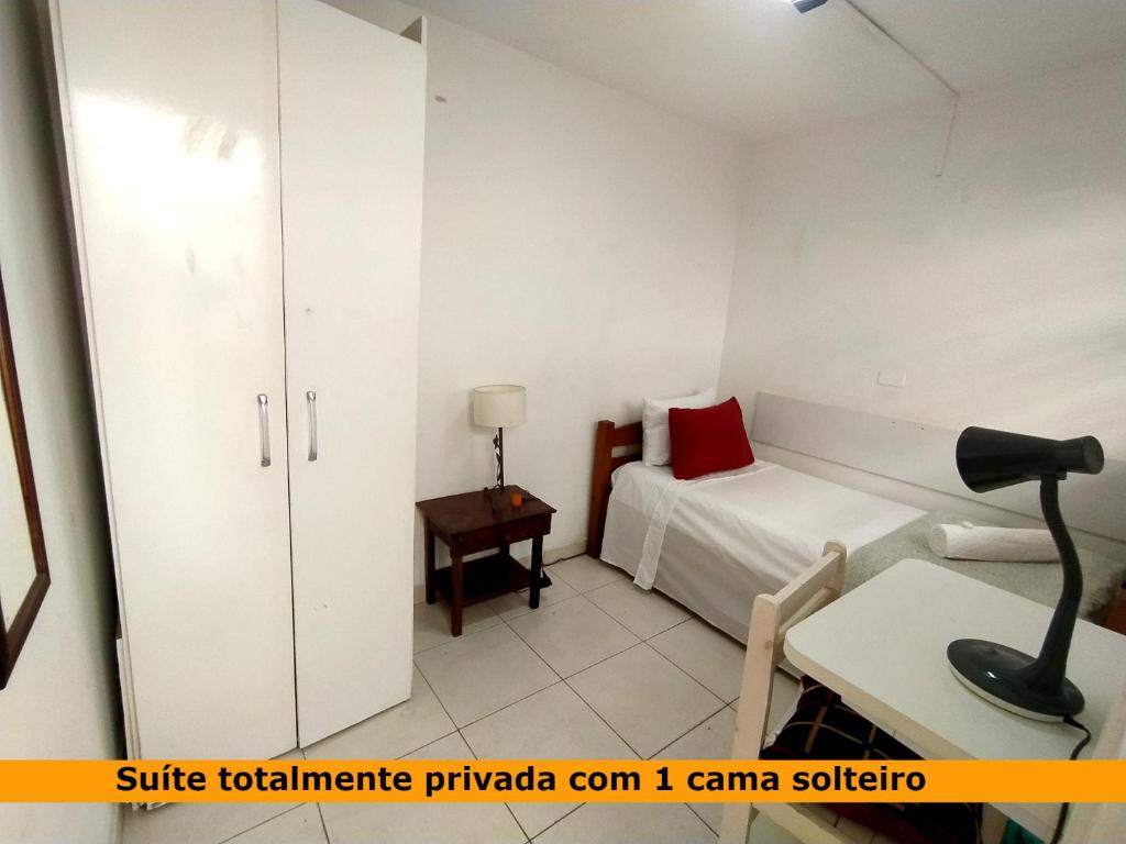 a bedroom with a bed and a desk with a lamp at Suite Kit Econômica Privativa 10 min Metrô e Aeroporto CGH in Sao Paulo