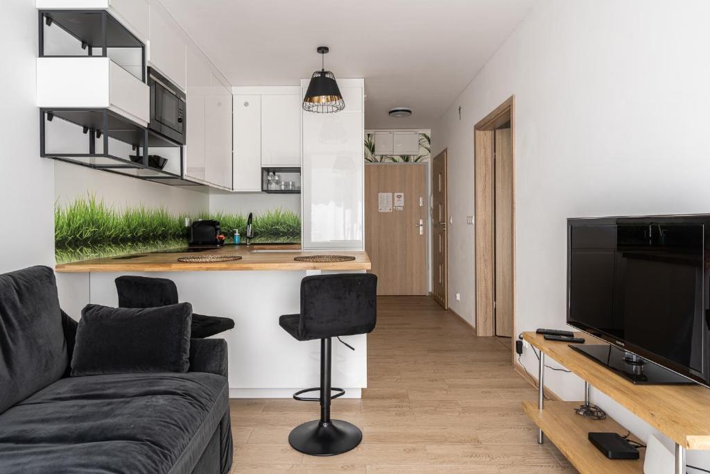 sala de estar con sofá y cocina en RentPlanet - Apartament Braniborska, en Wroclaw