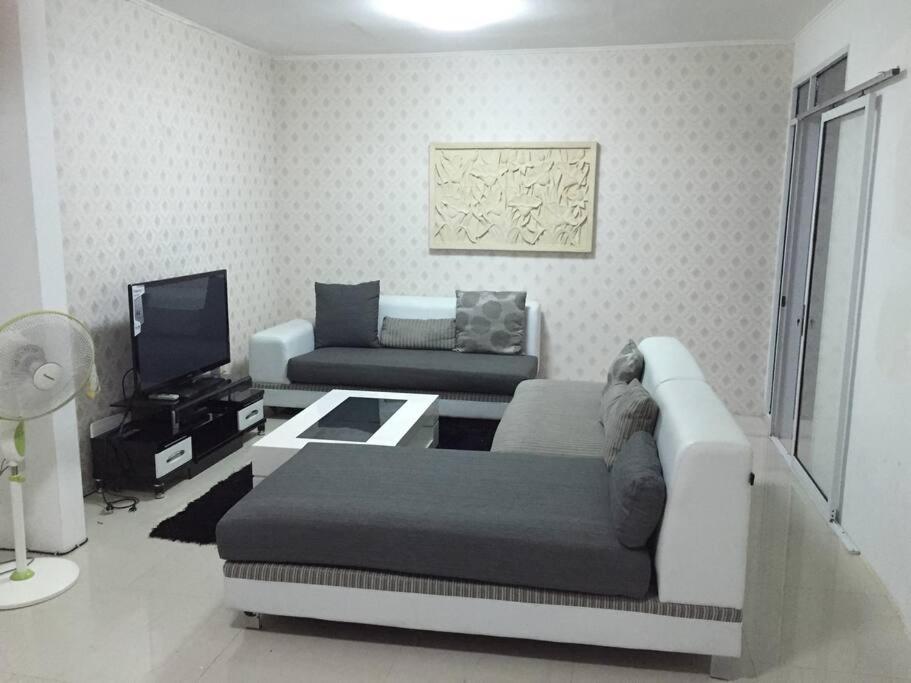 un soggiorno con divano e TV di Rumah di sewa di sentul city a Karangtengah