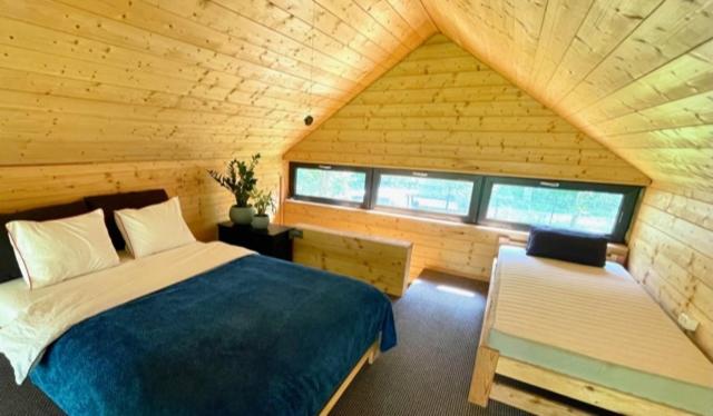 ein Schlafzimmer mit einem Bett in einer Holzhütte in der Unterkunft Leśny Azyl in Kępiaste
