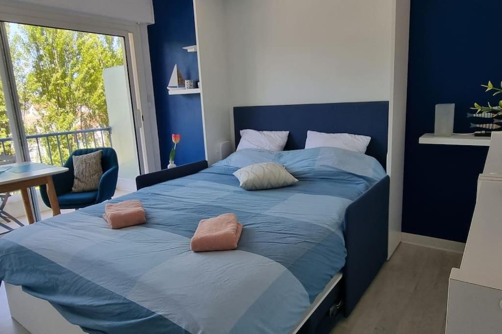 een blauw bed met 2 kussens in een slaapkamer bij Océan bleu - Studio bord de plage in La Baule
