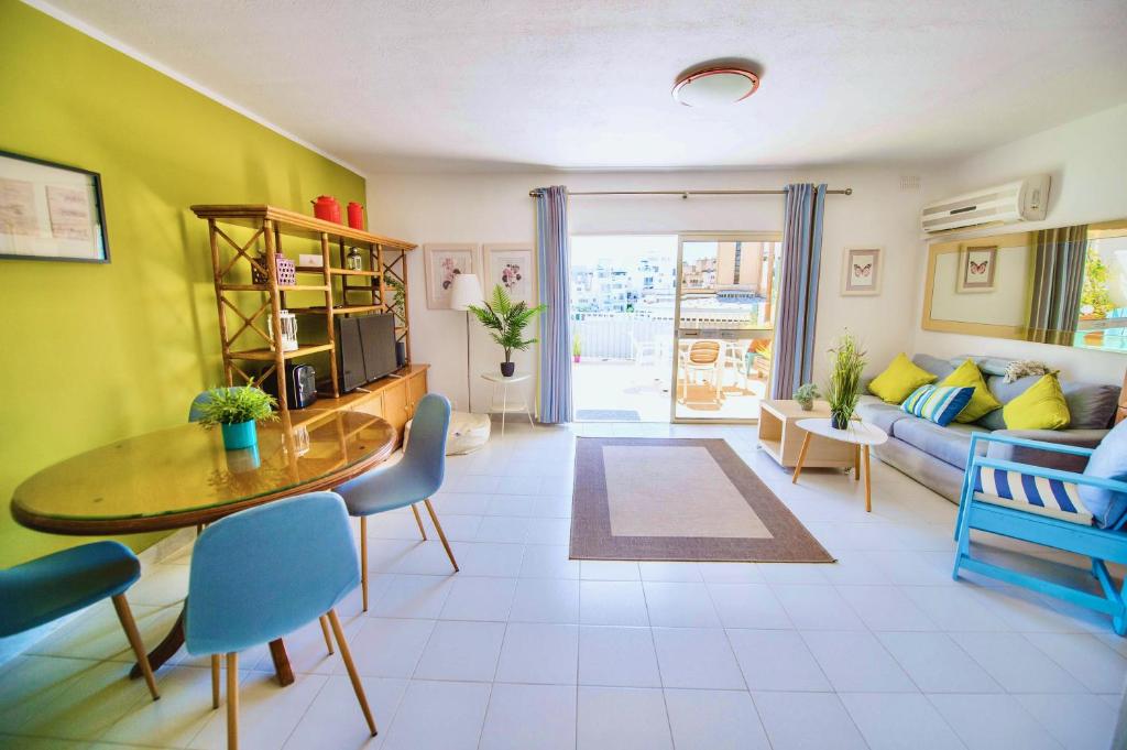 a living room with a table and a couch at Prime location: 3 Bedroom/3 Bath+Terrace in St. Julianʼs