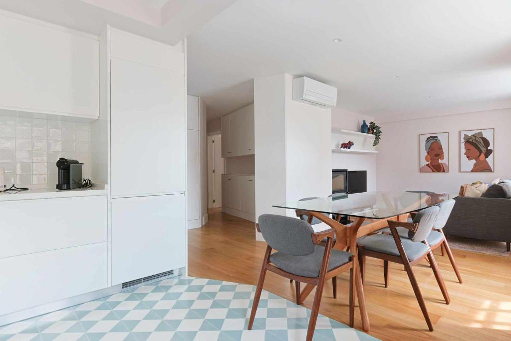 uma cozinha e sala de jantar com uma mesa de vidro e cadeiras em Downtown Charming Apartments Apartamento Castelo em Chaves