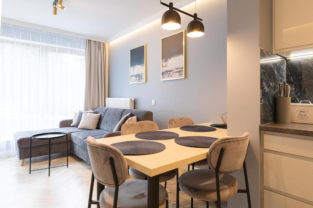 a kitchen and living room with a table and chairs at RentPlanet - Apartamenty Kilińskiego in Szklarska Poręba