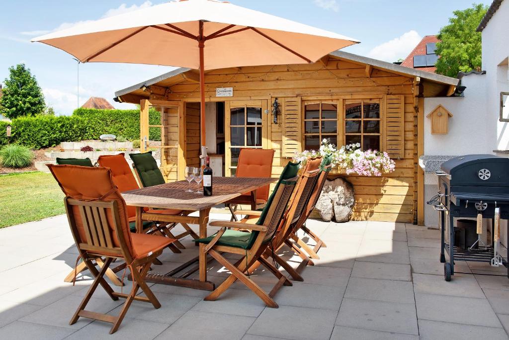 einen Holztisch und Stühle mit Sonnenschirm auf einer Terrasse in der Unterkunft Ferienwohnung Auszeit in Salem