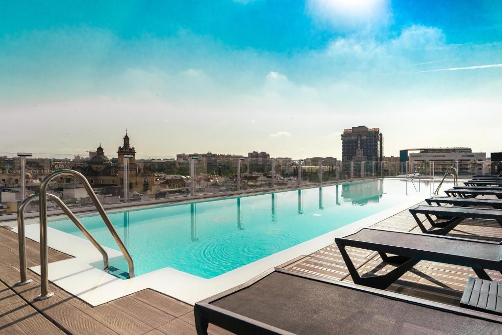 una gran piscina en la azotea de un edificio en Hotel Giralda Center, en Sevilla
