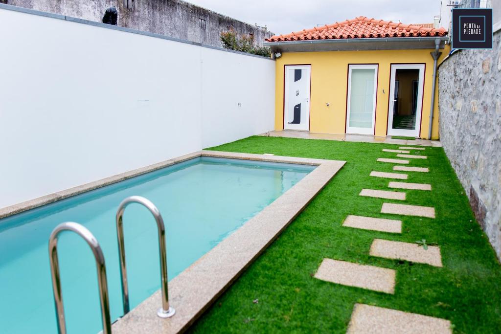 a swimming pool in a yard next to a house at Atrium Areias in Viana do Castelo